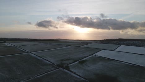 Eine-4K-Drohnenaufnahme-Eines-Wintersonnenuntergangs-Auf-Gefrorenen-Mooren