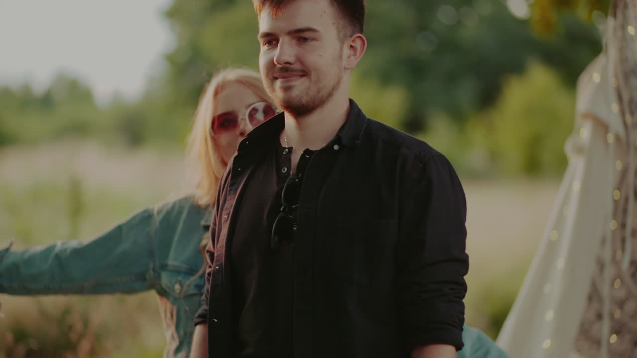 Donna positiva che sostiene un giovane uomo all'aperto al tramonto 6
