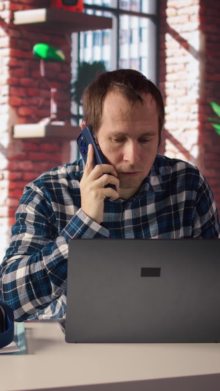 Vertical video Manager in home office sitting at desk in front of laptop, calling employee
