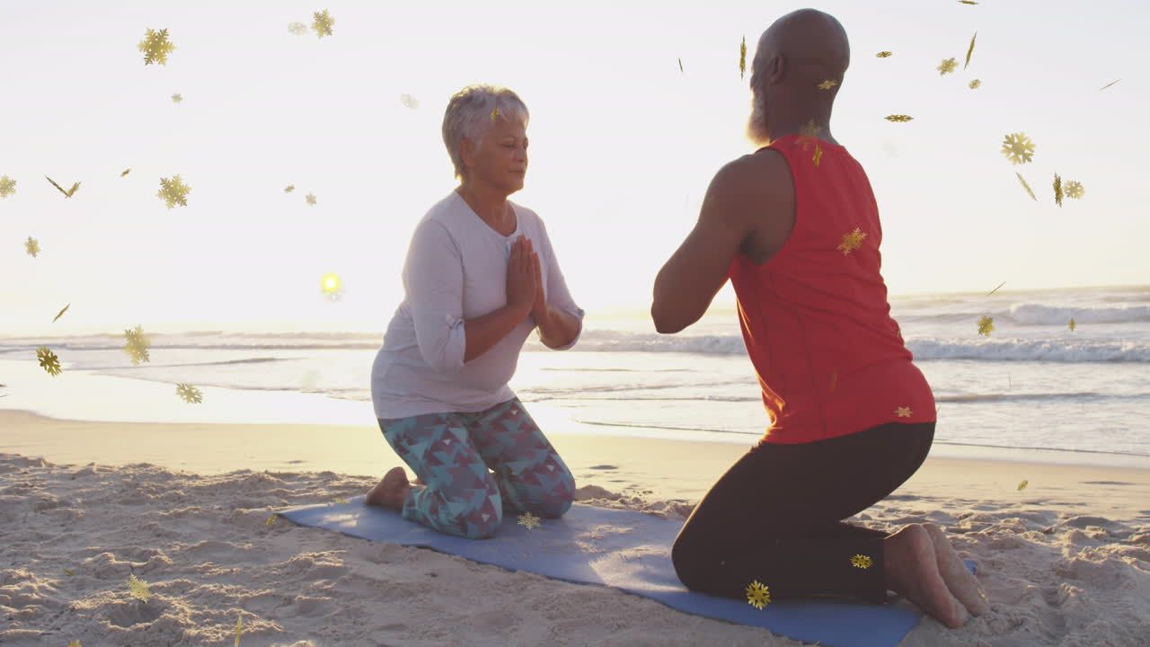 Practicing yoga on beach, two people kneeling with glowing particles animation over