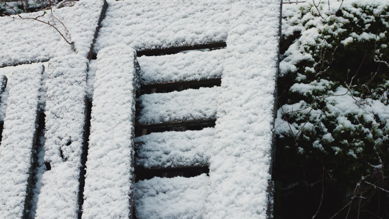 Neve che ricopre alcune tavole di legno in natura