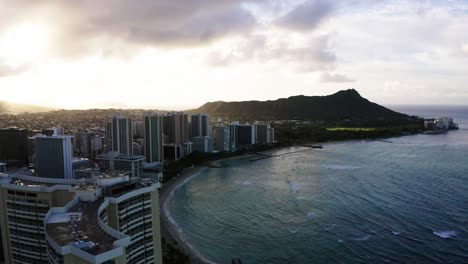 drone shot over the oahu sheraton hotel to reveal diamond head, an inactive volcano crater