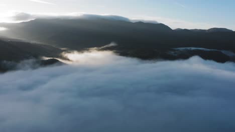 Dichter-Nebel,-Im-Gegenlicht-Der-Aufgehenden-Sonne,-Kriecht-Durch-Das-Weite-Tal