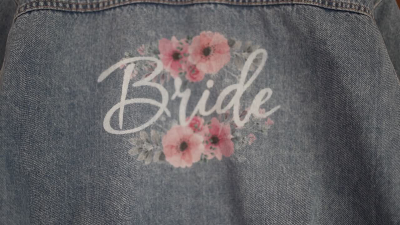 Primo piano di una scritta "sposa" con stampa floreale su superficie di tessuto.