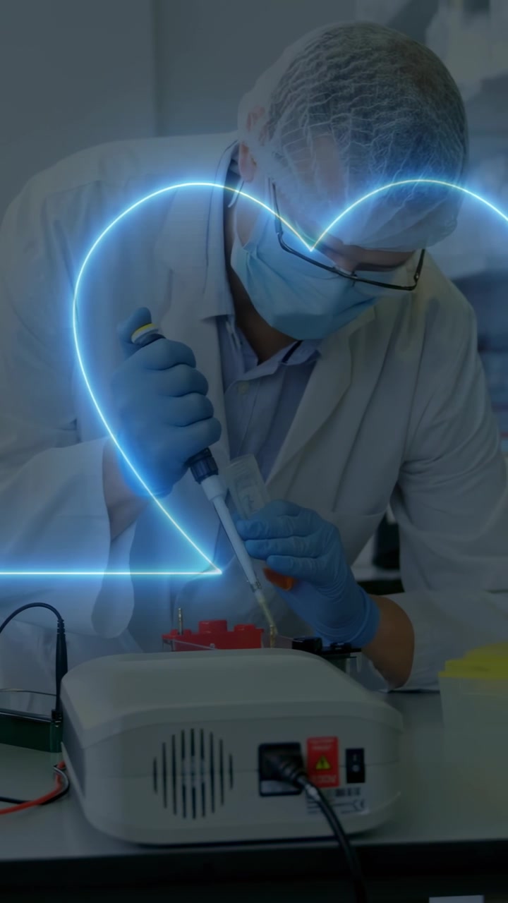 Video verticale: Tecnico di laboratorio uomo che pipetta in una rastrelliera rossa per test, con un cuore al neon sovrapposto al bancone.