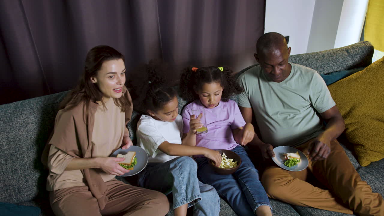 부모와 함께 집에서 영화를 보는 아이들