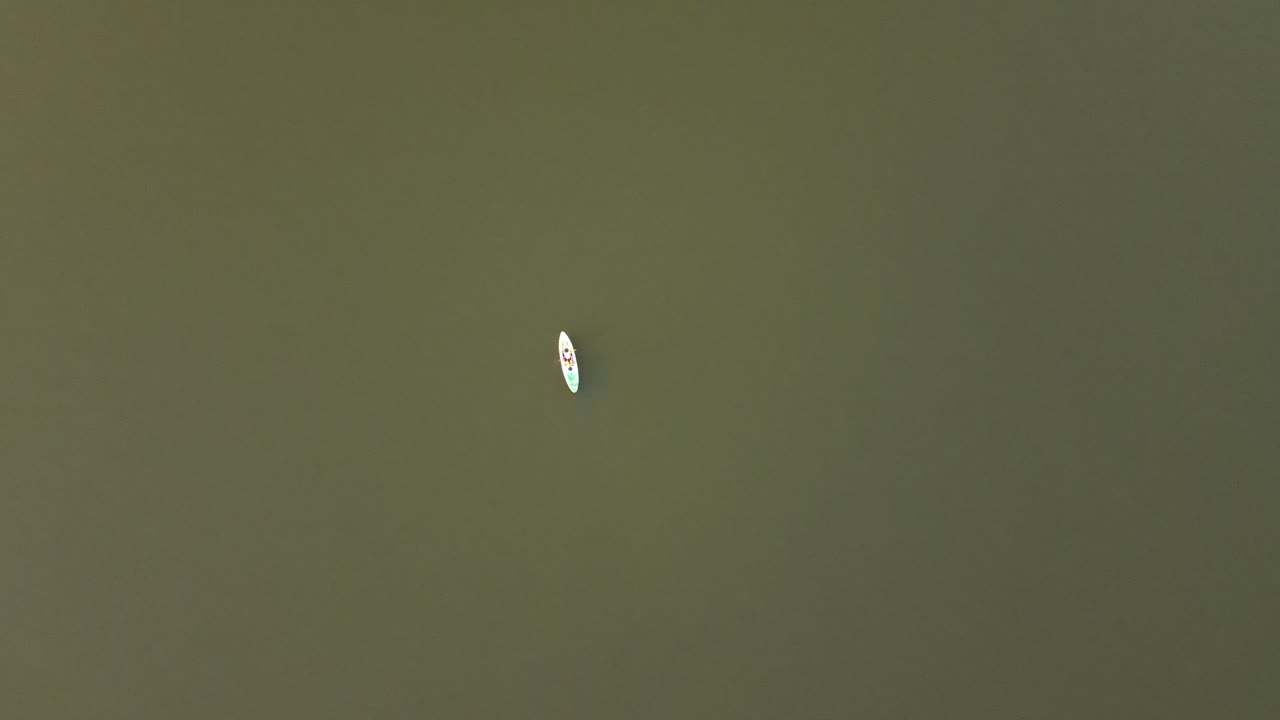 una persona remando en una canoa en un lago mirando directamente hacia abajo desde arriba en tailandia