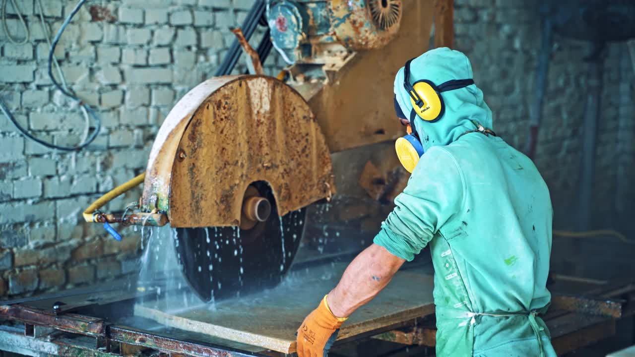 Process of cutting stone slab withautomated machine on the brick wall background.