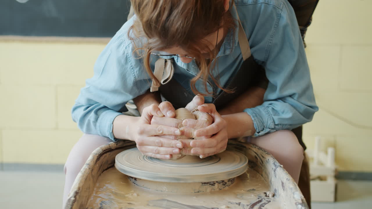 mujer aprendiendo cerámica en una rueda de cerámica