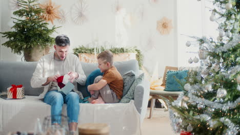 dad opens a christmas present from his son