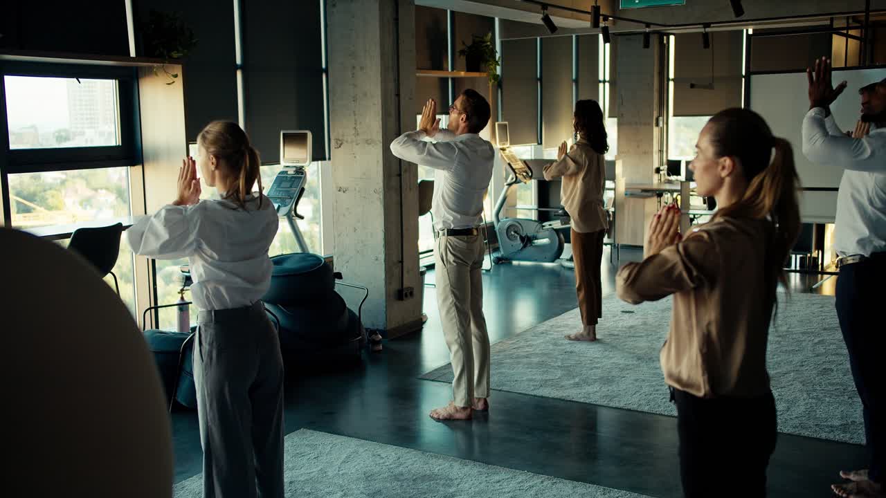 한 무리의 사업가들이 명상에 몰두하고 있습니다. 그들은 서로 가까이 서서 사무실에서 손을 잡고 있습니다.
