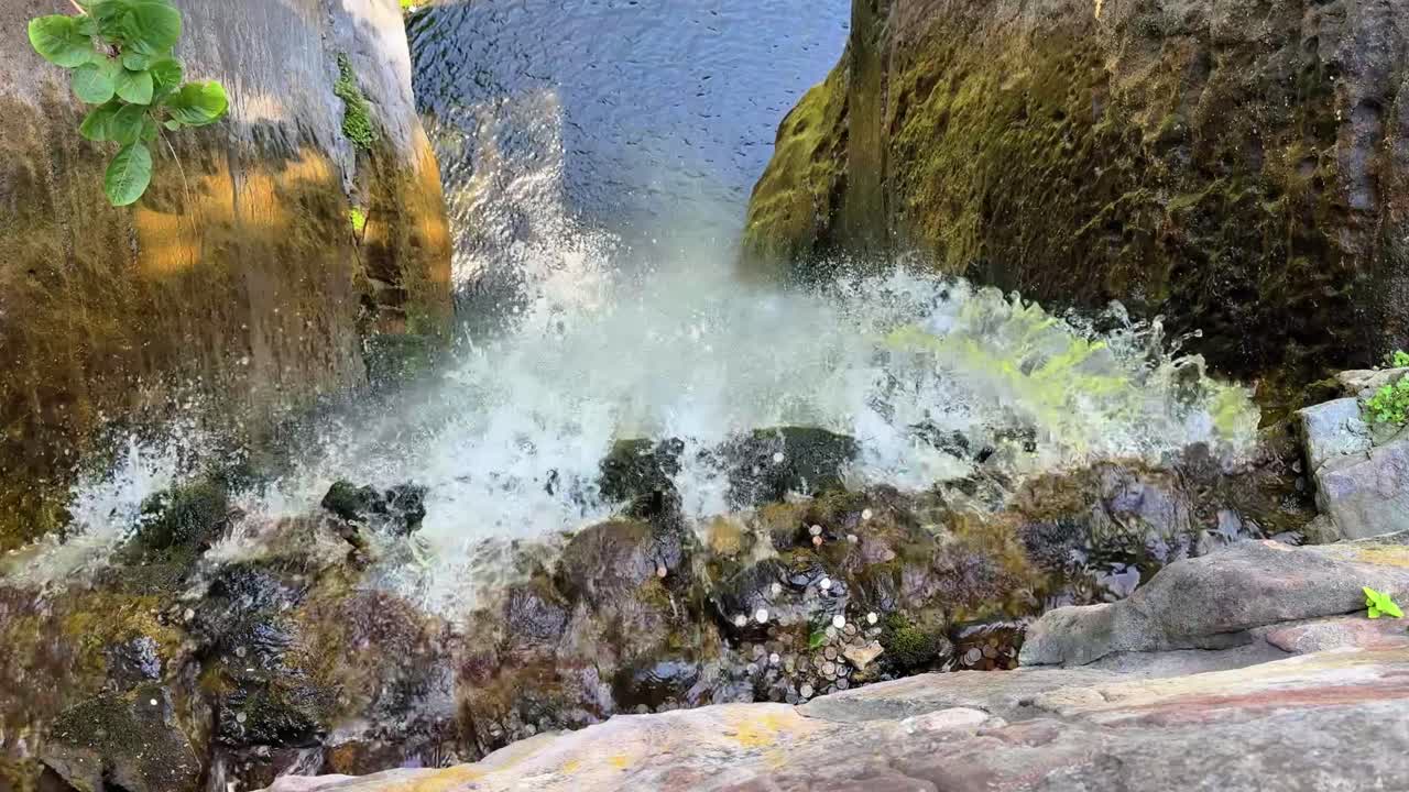 Water Flowing Over The Rocky Edge Of A Cascading Waterfall, Plunging Into A Lake In Slow Motion