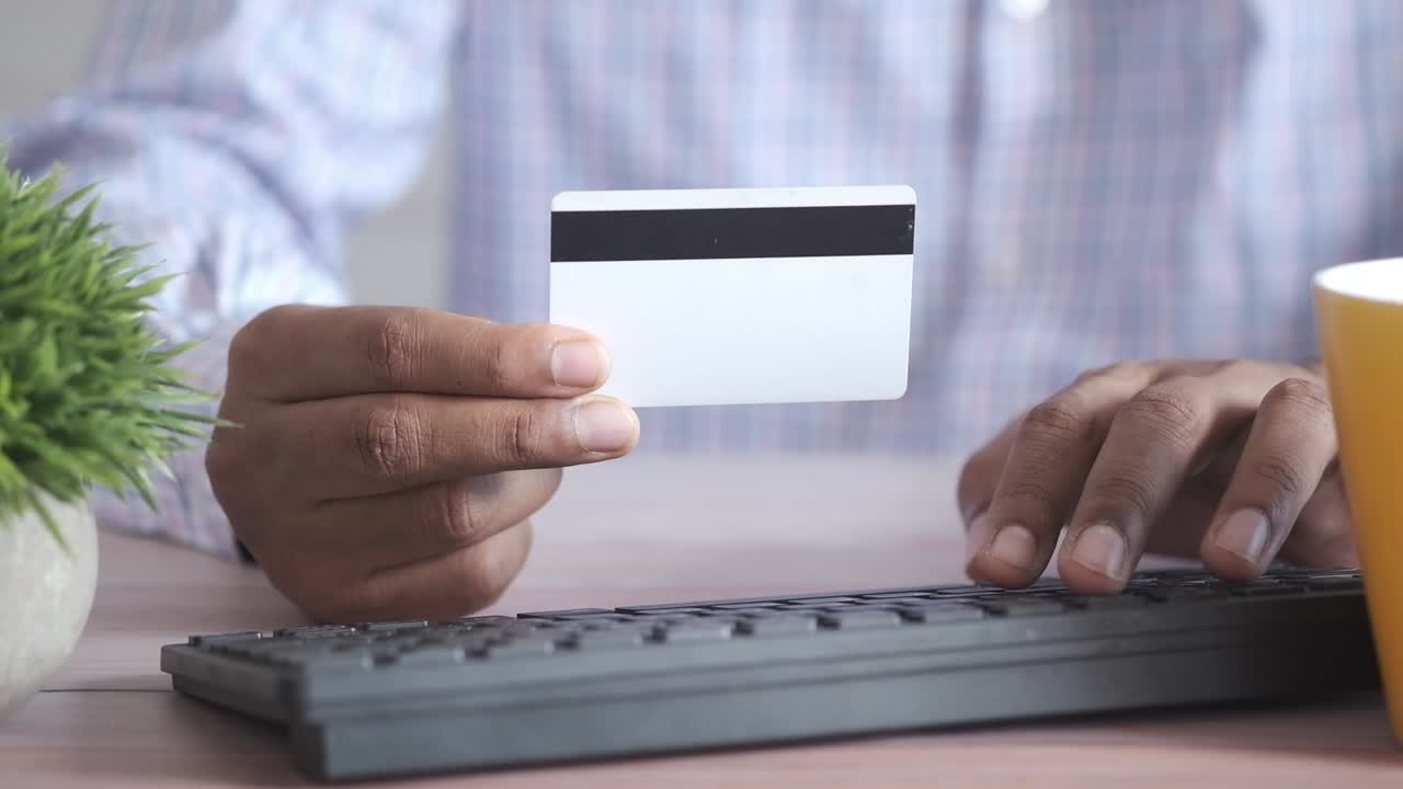 persona que utiliza una tarjeta de crédito para una transacción en línea