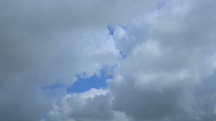 Cumulonimbus clouds gathering and blotting out blue sky