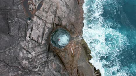 a man jumps into a rock pool