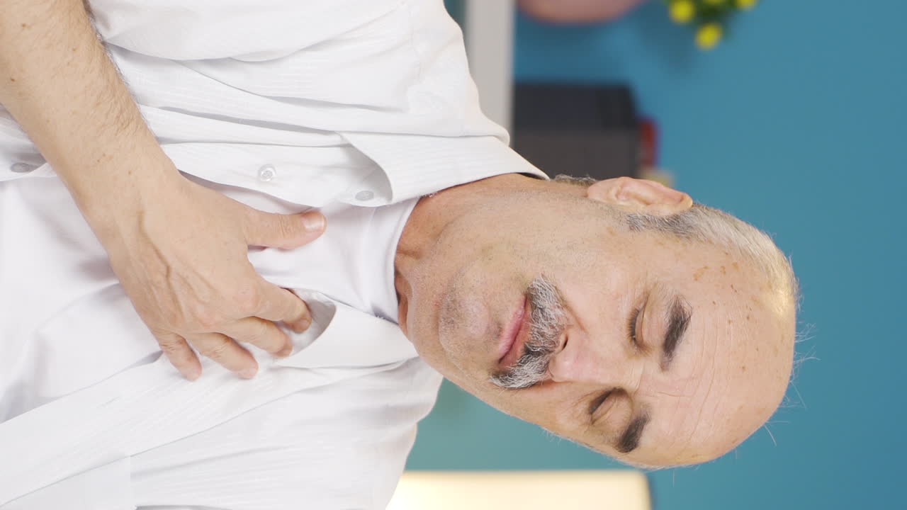 Vertical video of The sick old man can't stop coughing.