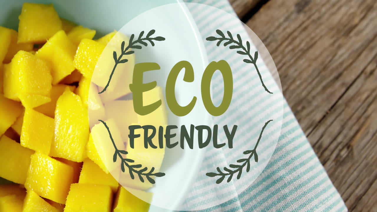 Animation of eco friendly text over mango pieces in bowl on table