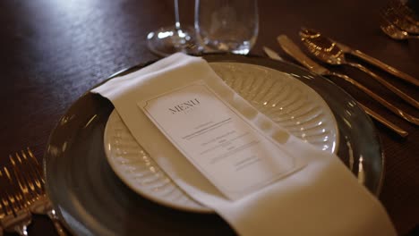 close up of formal table setting with printed menu and napkin