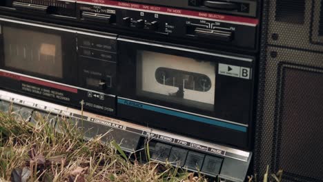 small child turns on the play button on an old, retro tape recorder