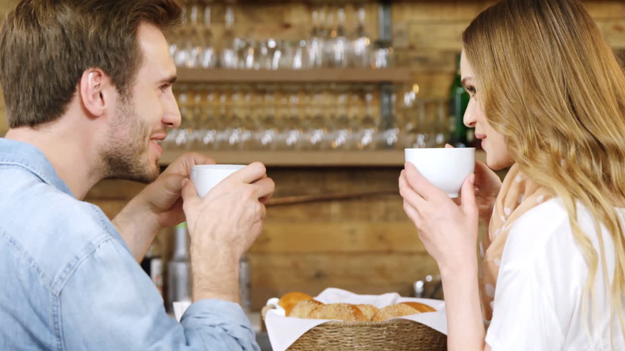 커플 4k 카운터에서 커피를 마시고 있습니다.