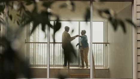 senior couple dancing on a balcony