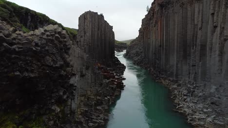 cañón studlagil, amplio empuje, río azul en islandia con columnas de roca basáltica, vista frontal