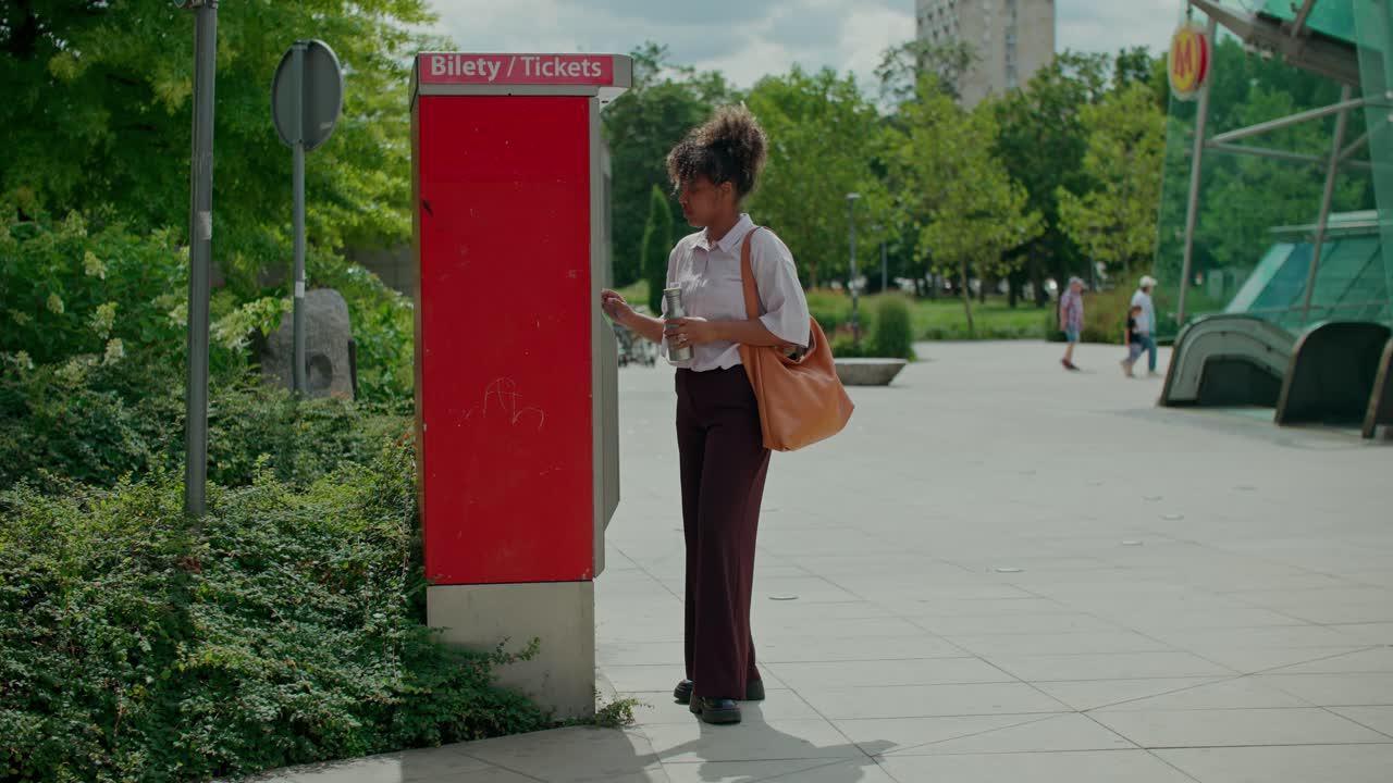 Una mujer usando un expendedor de billetes en un entorno urbano