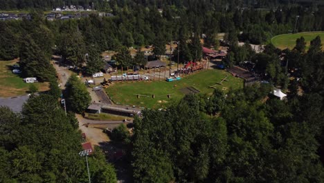 una impresionante vista aérea de 4k del estadio en squamish, bc revela un campo vibrante que alberga el festival loggerfest y sus muchos eventos deportivos