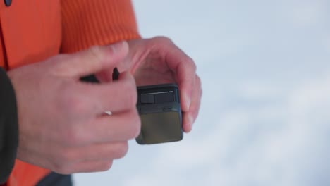 Öffnen-Des-Batteriesteckplatzes-Der-Creative-Insta360-Ace-Pro-Action-Kamera-Mit-Schnee-Im-Hintergrund