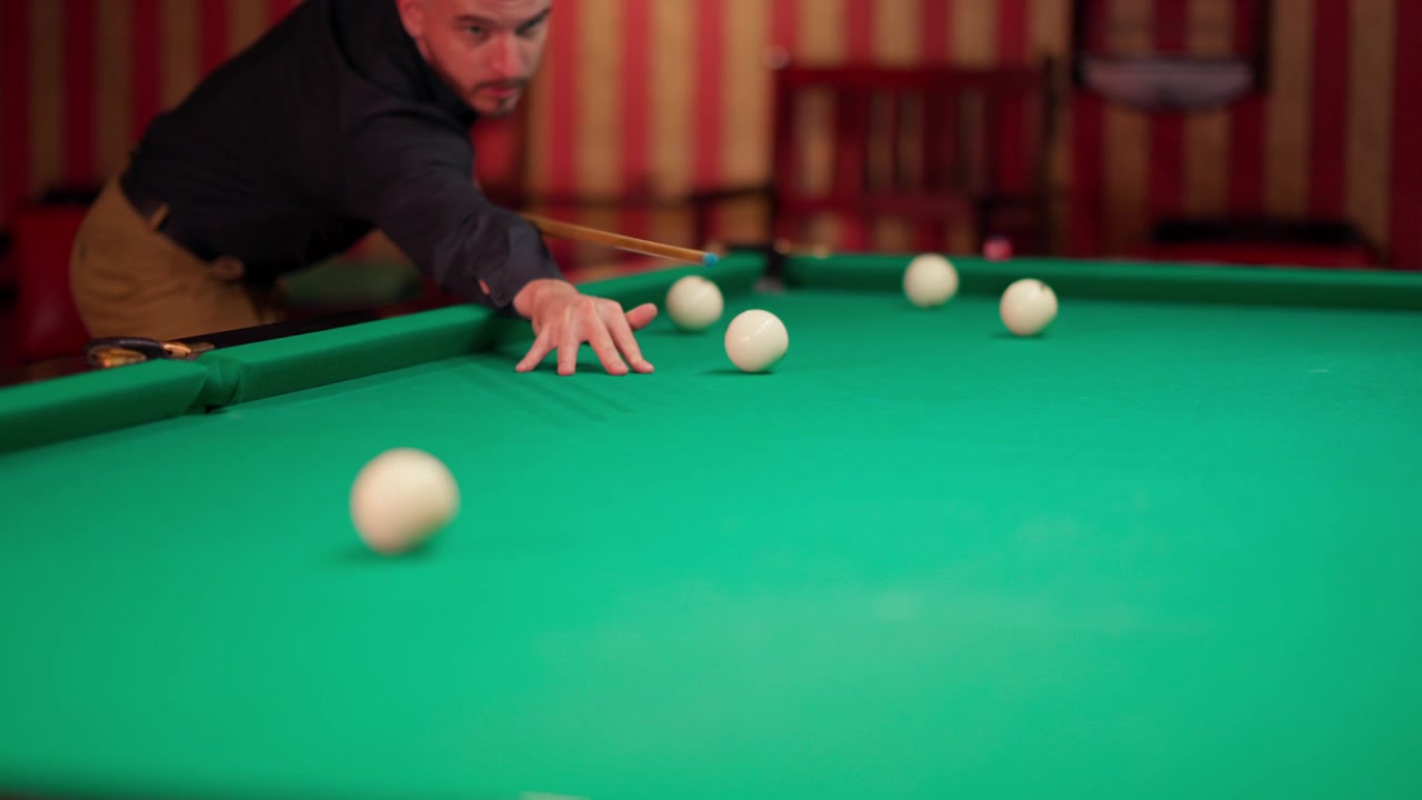 Man die biljart speelt, een stoot neemt op een groene biljarttafel