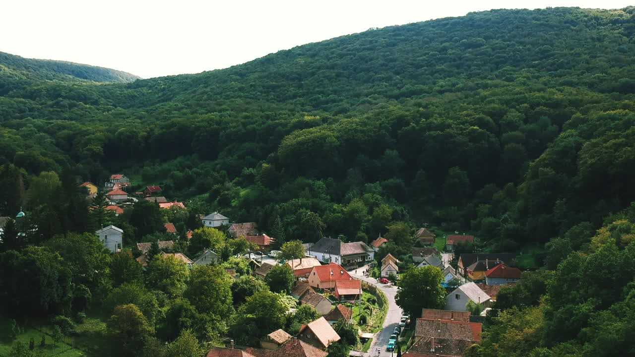 Arial shot of a remote Hungarian village, surrounded by mountains and forest