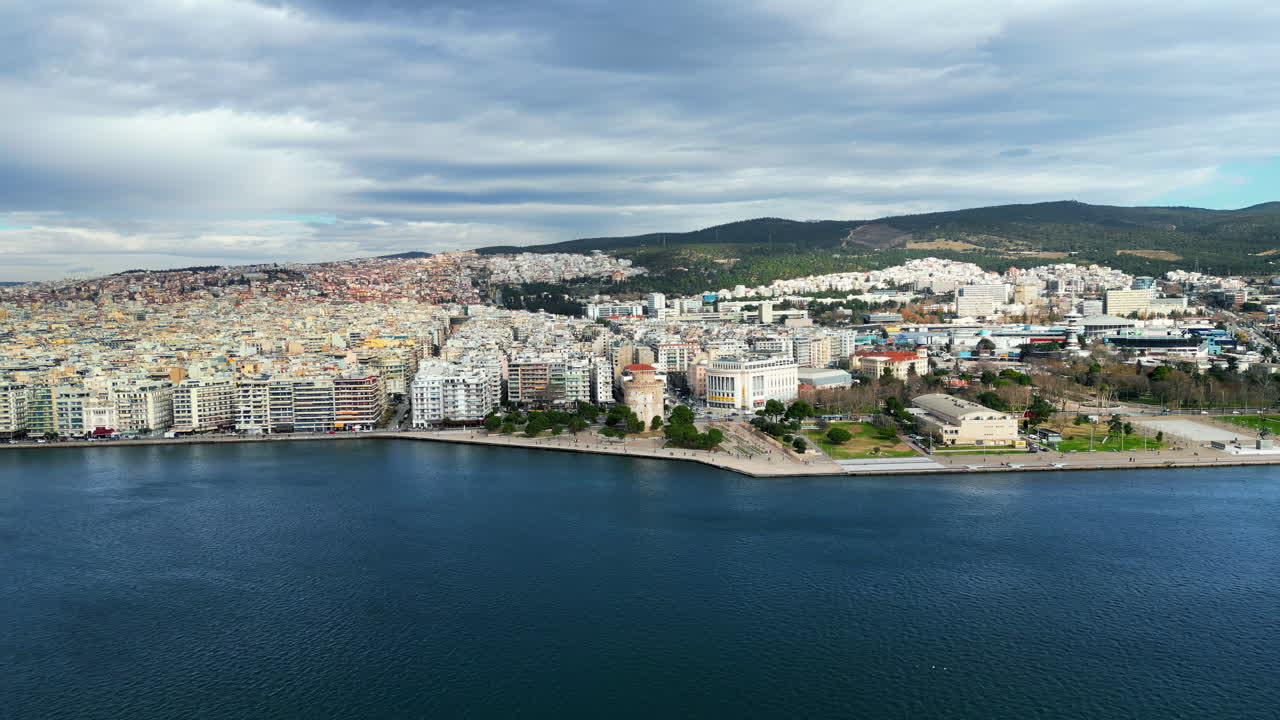 Aerial drone view of Thessaloniki coastline. Monument and museum the White Tower on the waterfront of the city. The Aegean Sea in Central Macedonia in Greece