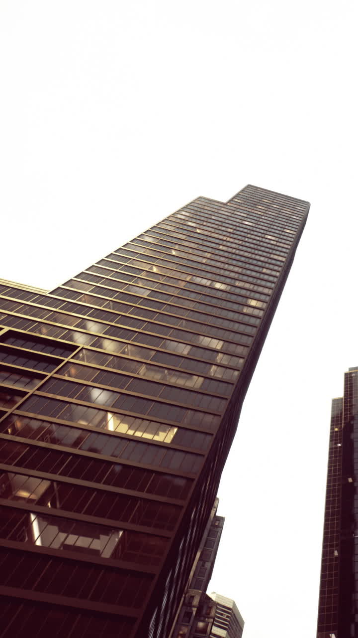 Edifício alto com fachada de vidro reflexivo que mostra paisagem urbana no centro da cidade