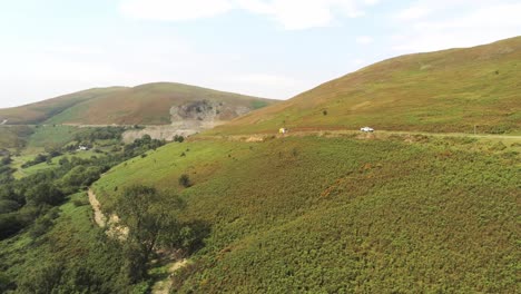 aerial view traffic driving on horseshoe pass lush scenic misty mountain valley picturesque rural countryside