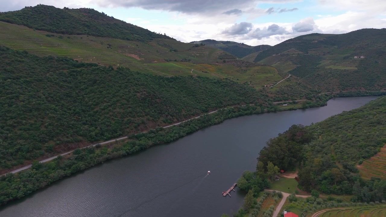 Vista aerea del fiume Douro che serpeggia tra vigneti a terrazze e colline boscose nel Portogallo settentrionale.