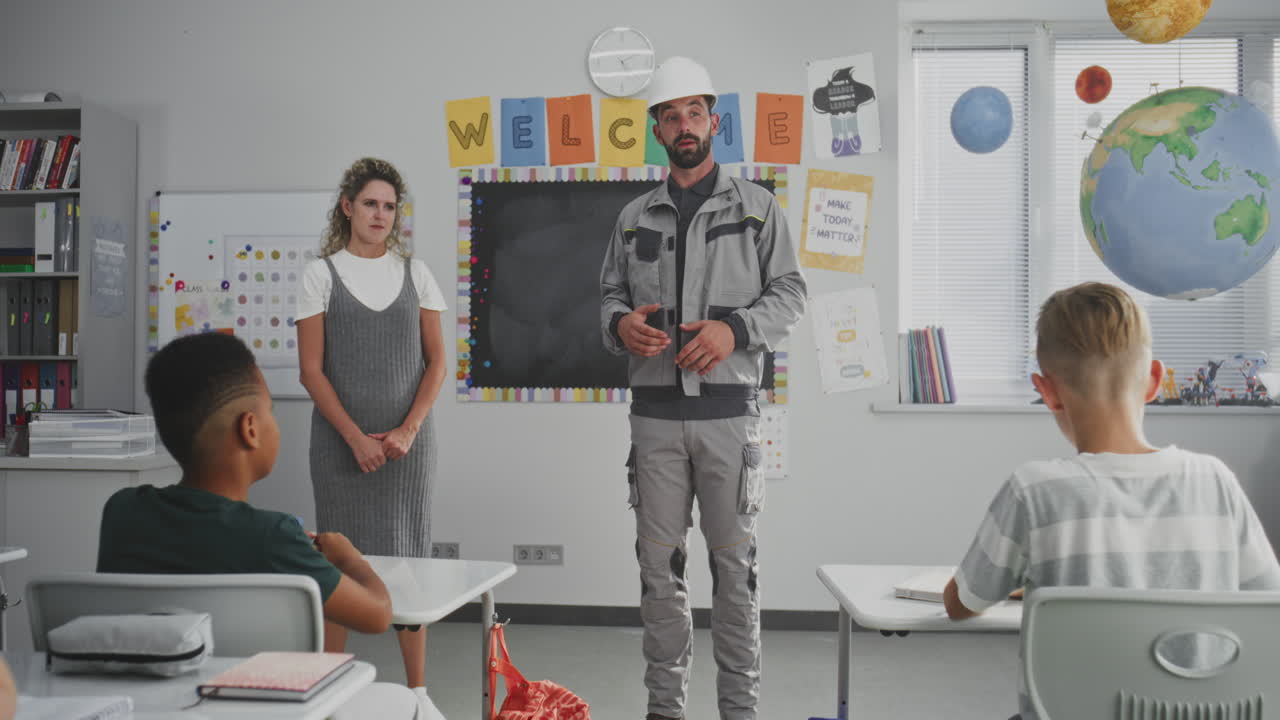 Engineer in Uniform Speaking and Giving Lecture to Curious Primary School Students About Engineering