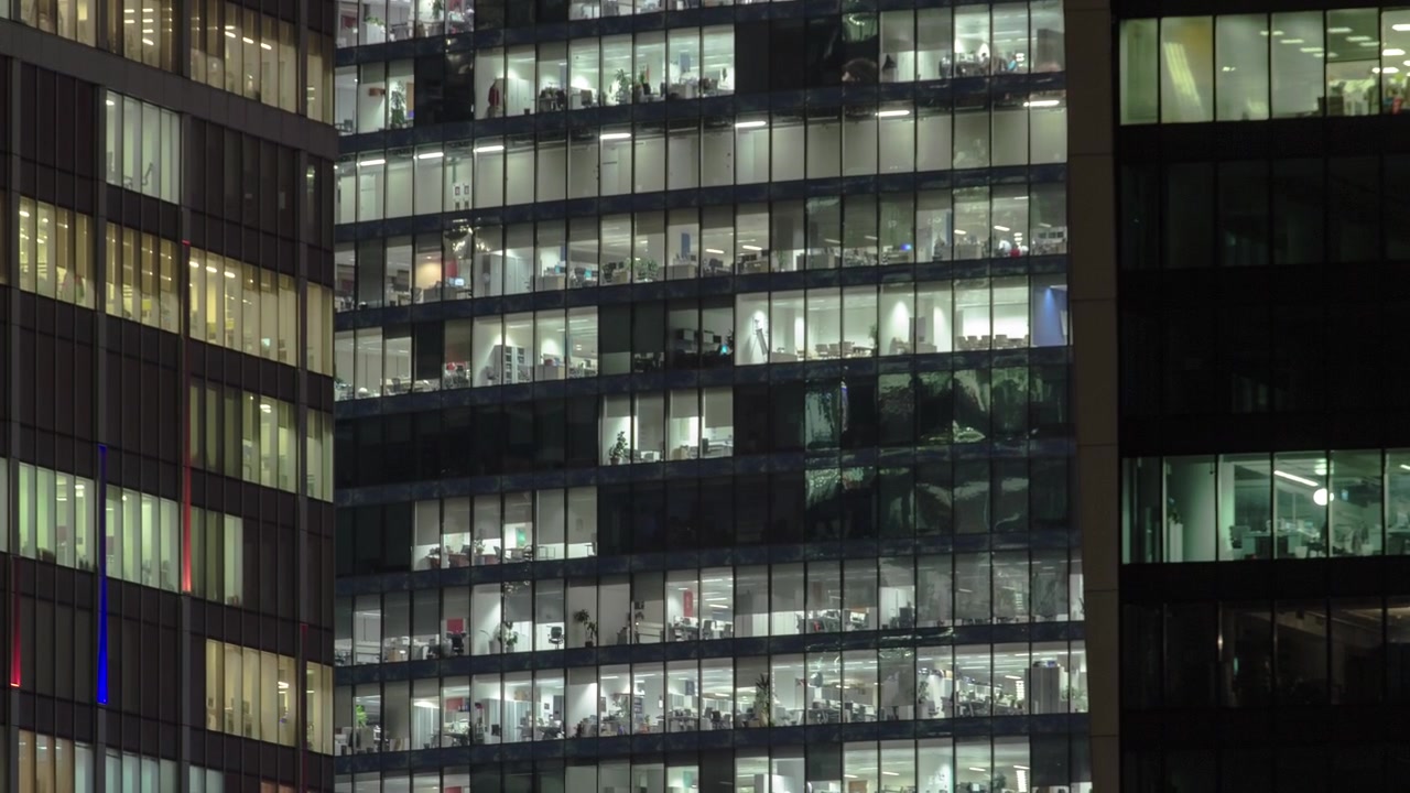 Vista cercana de las ventanas de oficinas en los rascacielos del Centro Internacional de Negocios de la Ciudad por la noche, con un timelapse del río Moscova desde arriba, Moscú, Rusia.