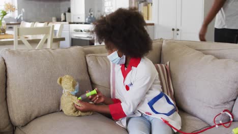 African-american-girl-playing-doctor-and-patient-with-her-teddy-bear