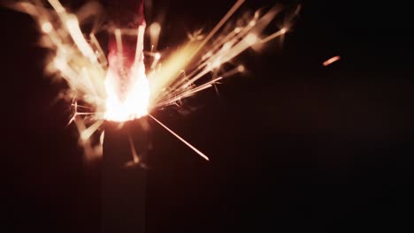 Video-of-close-up-of-sparkler-and-copy-space-on-black-background