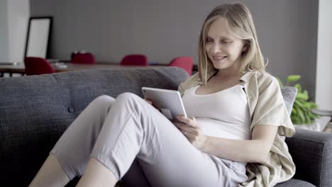 smiling pregnant woman using tablet