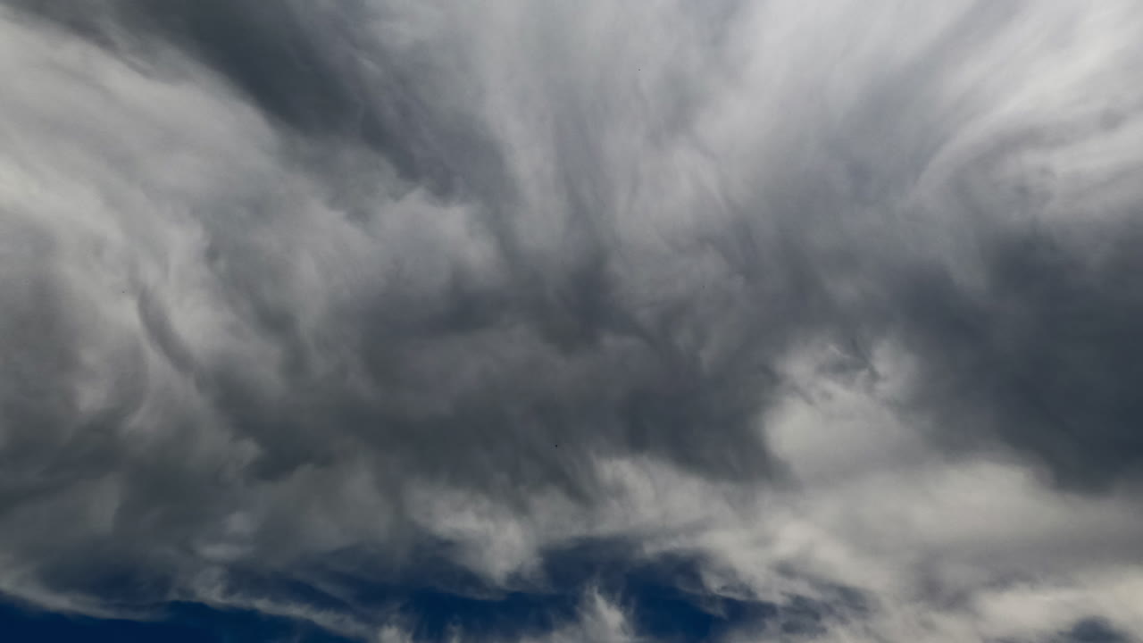 Mesmerizing transformation of clouds in the sky. Slowly moving grey cloudscape low angle view. Timelapse.