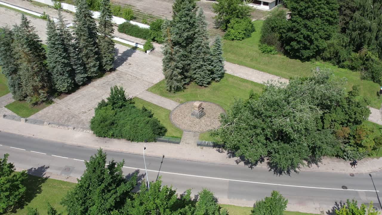 Drone moves forward toward jewish memorial monument near abandoned Soviet building Vilnius