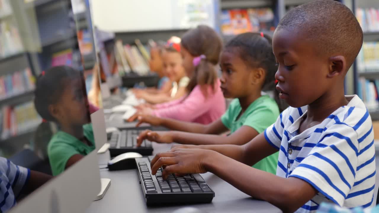 Side view of mixed-race schoolkids studying on computer in the classroom 4k