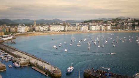 Barcos-En-Un-Puerto-Tranquilo-Durante-La-Puesta-De-Sol-En-Un-Día-Soleado-En-San-Sebastián-España-Europa,-Tiro-Panorámico