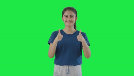 una adolescente india feliz mostrando los pulgares hacia arriba pantalla verde