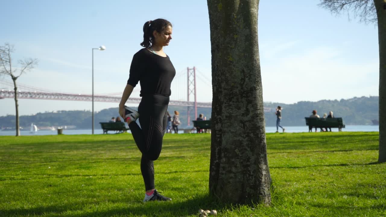 chica morena atractiva en ropa deportiva haciendo ejercicio en el parque