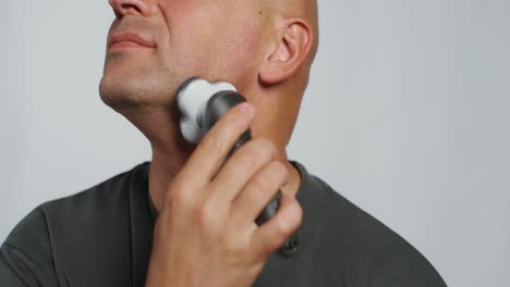 man shaving with electric razor