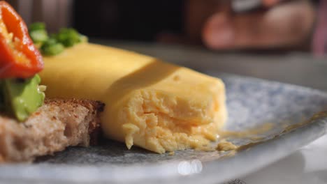 close up of omelet with toast and avocado