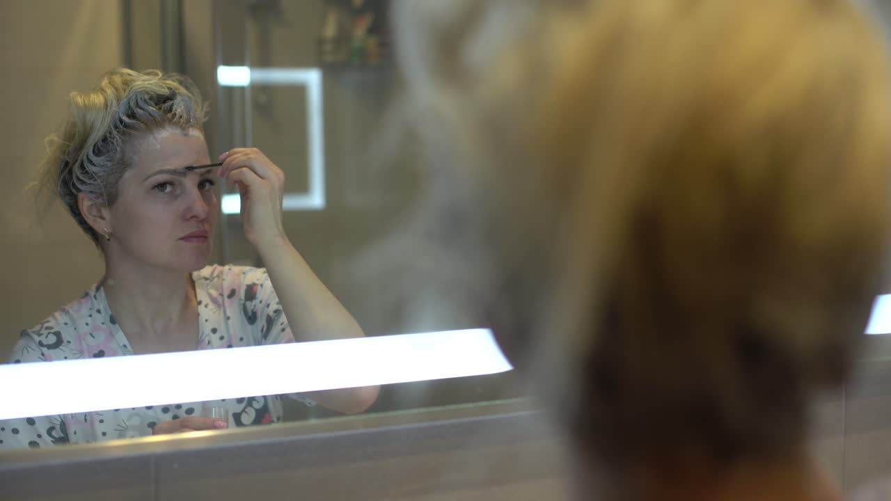 la donna si tinge i capelli e le sopracciglia da sola