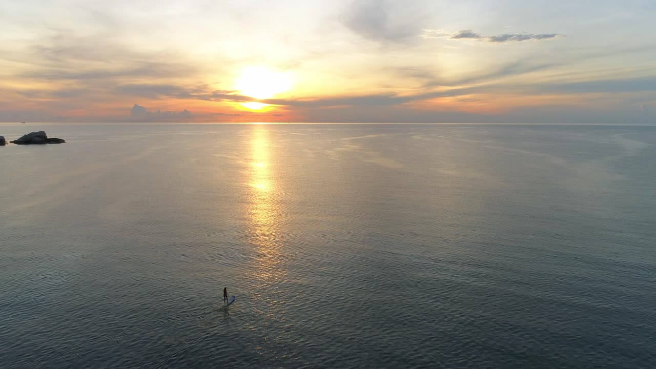 Two People Paddleboarding at Sunrise